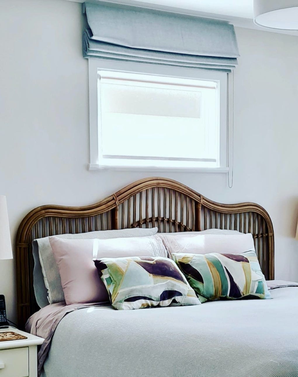 Studio 28 Interio Design Wellington Zealand. Creating wow interiors that are easy on the eye. Bedroom showing ccane bedhaed and beside lamp with decorative pillows.