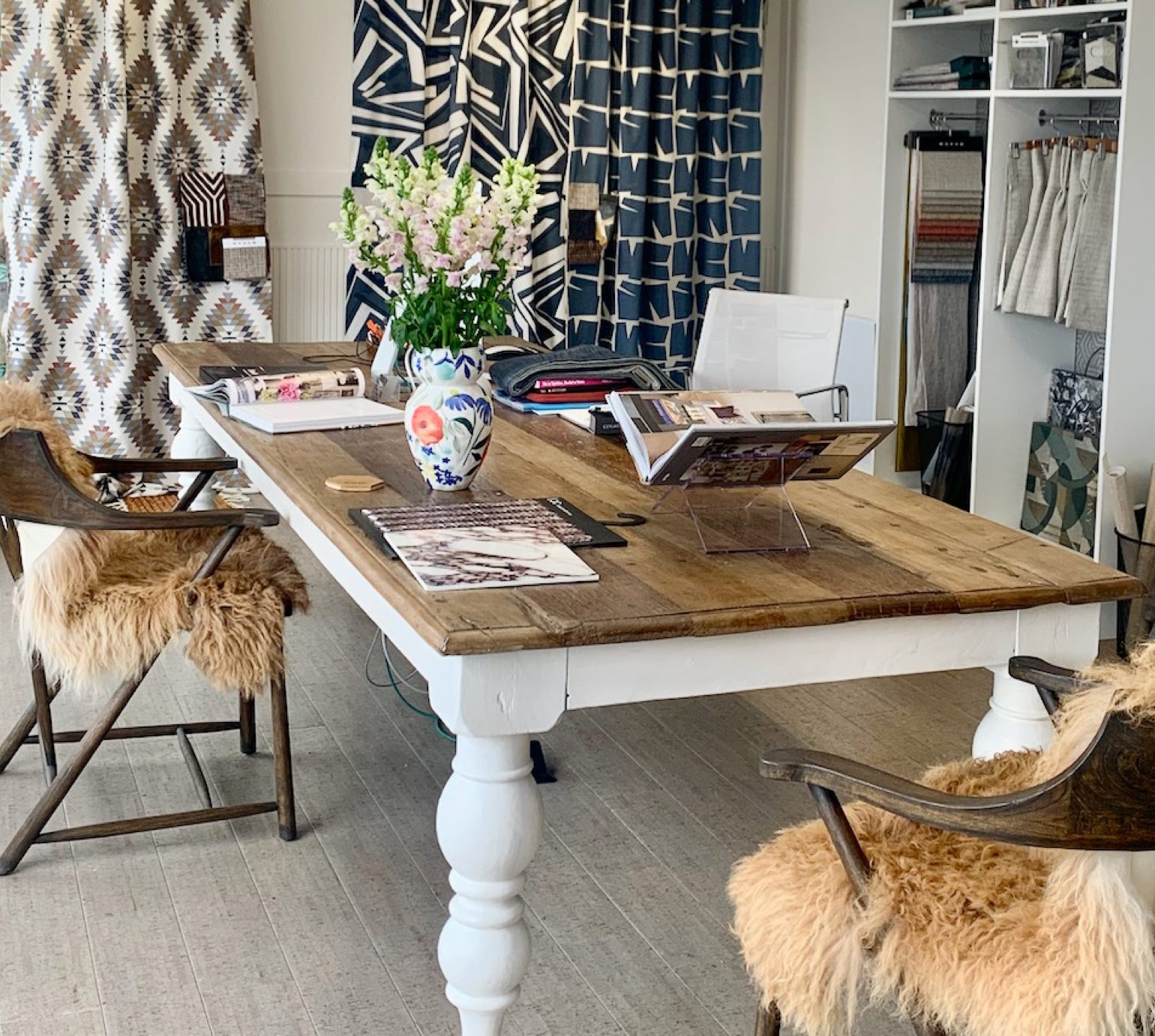 Studio 28 Interio Design Wellington Zealand. Creating wow interiors that are easy on the eye.Inside the interior design studio a large table with books and samples. Curtain samples in the background. 